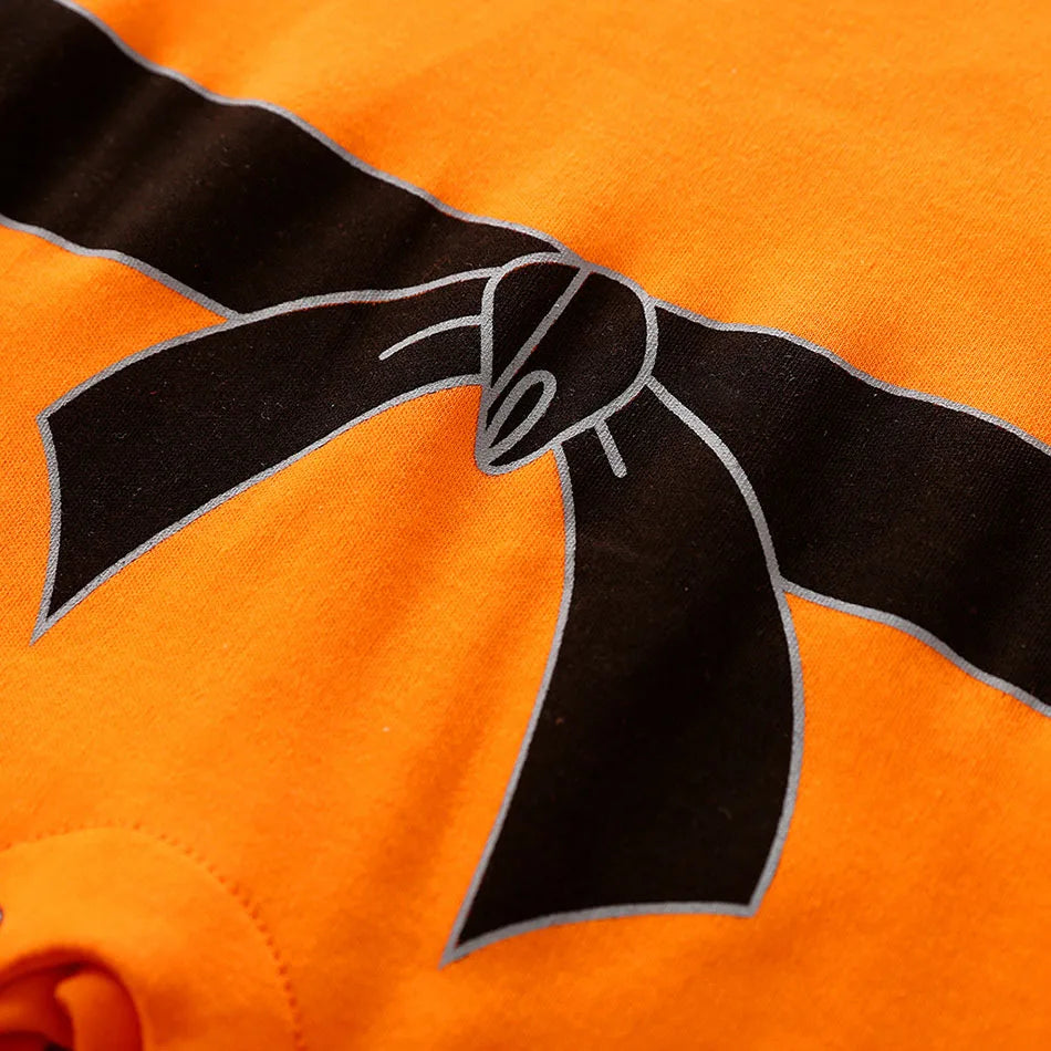 Baby anime romper belt detail close-up with orange and black bow design